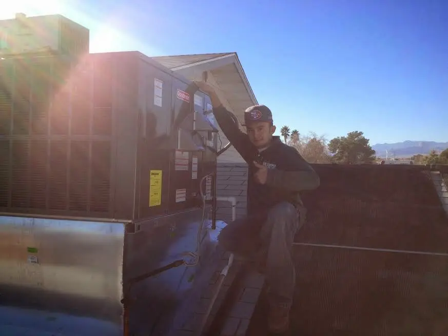 HVAC technician performing AC Tune-Up on a rooftop unit in Westminster